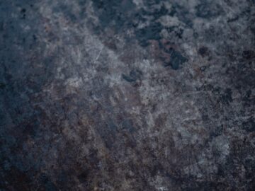 Close-up of a weathered metallic surface showcasing rugged texture and dark tones