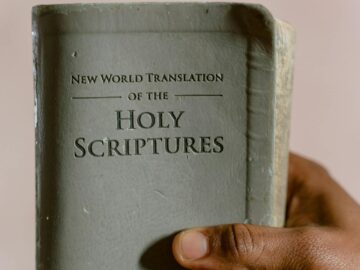 Close-up of a hand holding the New World Translation of the Holy Scriptures.