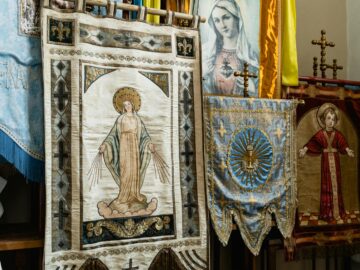 Detailed view of ornate religious tapestries depicting saints and holy figures inside a church.