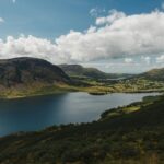 Explore the stunning landscape of Ennerdale Water with mountains and lush greenery.