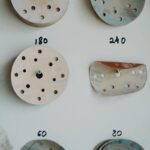 A variety of sandpaper discs with different grit sizes neatly arranged on a workshop wall.