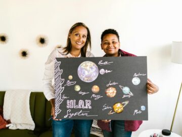 A mother and son proudly display their handmade solar system project.