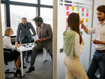 Office environment with diverse team members brainstorming and collaborating on a project.