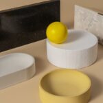 Minimalist still life with geometric shapes and a lemon on a neutral background.