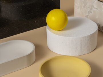 Minimalist still life with geometric shapes and a lemon on a neutral background.