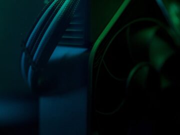 Dark close-up of a gaming PC cooling system with visible wires and fan.