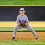 Young softball player focused and ready on the infield during a game.