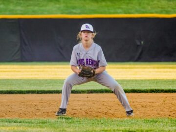 Young softball player focused and ready on the infield during a game.