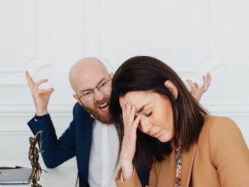 Two colleagues in a law office engaging in a tense discussion, showcasing frustration and stress.