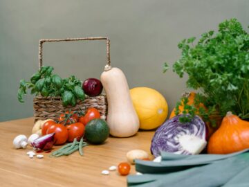 Assorted fresh vegetables and herbs on a wooden table enhancing culinary inspiration.