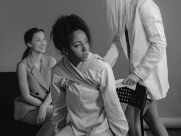 Black and white photo of diverse women discussing social issues, emotional portrayal.