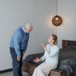 Elderly couple in a heartfelt conversation indoors, expressing emotions and connection.