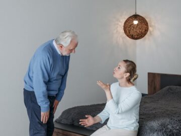 Elderly couple in a heartfelt conversation indoors, expressing emotions and connection.