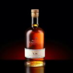 A bottle of Armagnac VS with a cork, elegantly displayed against a dark background.