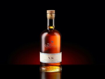 A bottle of Armagnac VS with a cork, elegantly displayed against a dark background.