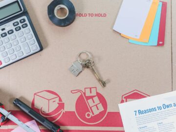 Flat lay of home buying essentials with calculator, keys, tape, and color swatches.