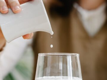 Close-up of a woman pouring milk into a glass, highlighting a healthy lifestyle.