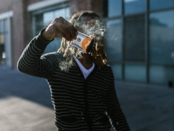 A person on city streets burning US dollar bills symbolizing cryptocurrency like Bitcoin.