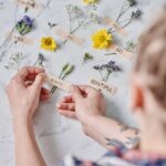 Hands arranging flowers with positive words on a marble surface. Ideal for art and inspiration themes.