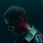 Conceptual cyberpunk portrait of a man in sunglasses and leather jacket with dramatic lighting.