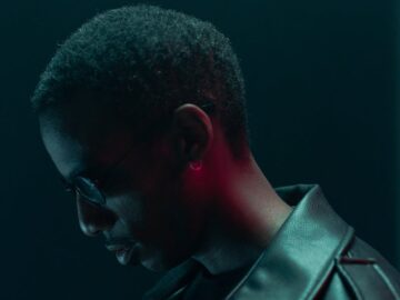 Conceptual cyberpunk portrait of a man in sunglasses and leather jacket with dramatic lighting.