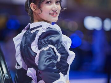 A smiling woman in a maid costume poses confidently, highlighting cosplay culture.