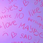 Pink handwritten words like love, hate, and maybe on a gradient background.