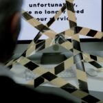 A man views a rejection message on a computer screen blocked by caution tape, symbolizing unemployment.