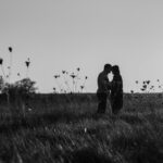 a group of people standing in a grassy field