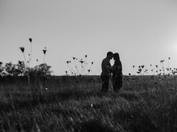 a group of people standing in a grassy field