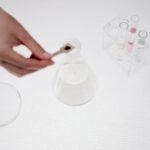 Close-up of a person handling a beaker in a science lab setting.
