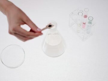 Close-up of a person handling a beaker in a science lab setting.