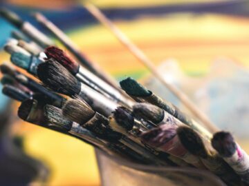 Close-up of colorful paintbrushes in a creative and artistic setting, evoking a lively studio atmosphere.