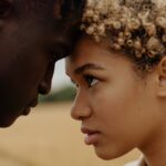 Close-up portrait of a couple sharing an intimate moment outdoors.