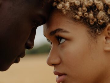 Close-up portrait of a couple sharing an intimate moment outdoors.