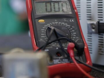Close-up shot of a multimeter used for electrical measurements, with focus on the display.