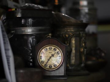 A vintage clock amidst a collection of antique objects, evoking a nostalgic feel.