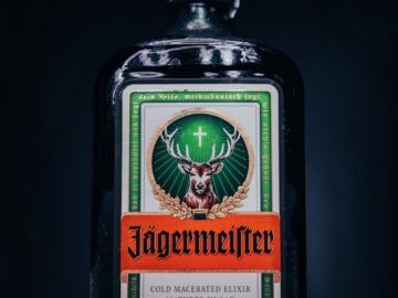 A sophisticated Jägermeister bottle stands out against a dark backdrop, showcasing its iconic label.