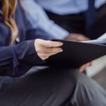 Two professionals in business attire reviewing documents, conveying teamwork and collaboration.