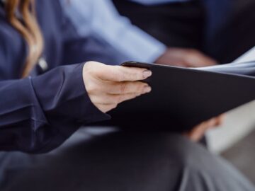 Two professionals in business attire reviewing documents, conveying teamwork and collaboration.