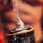 Dynamic shot of protein powder being added to a shaker, fitness concept.