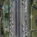 Highway traffic captured from above showcasing trucks and parked vehicles in Roncade, Italy.
