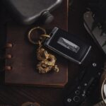 Elegant rustic arrangement of car key, dragon pendant, and vintage accessories.