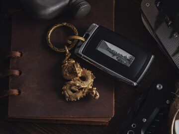 Elegant rustic arrangement of car key, dragon pendant, and vintage accessories.