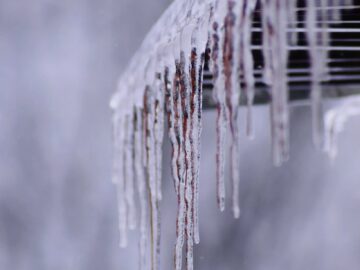 Close-up view of icicles formed on a roof edge during winter.