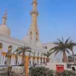 A stunning view of a mosque with tall minarets and intricate architecture during dusk, reflecting spiritual elegance.