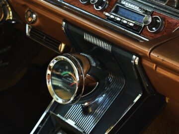 Interior view of a vintage car dashboard featuring retro audio equipment and classic design elements.
