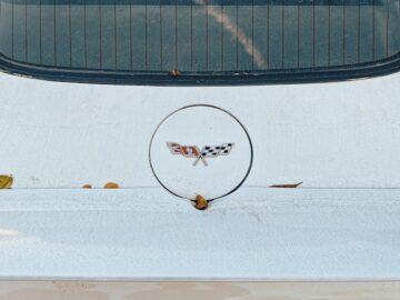 Detailed rear view of a white Corvette sports car showcasing its emblem.