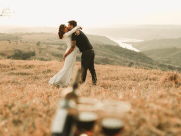 A couple embraces romantically in a picturesque outdoor setting, creating a memorable moment.