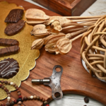 An artistic still life featuring chocolate confections, a vintage key, and rustic decor elements on a wooden board.